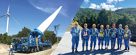 風力発電の機械と職員の集合写真